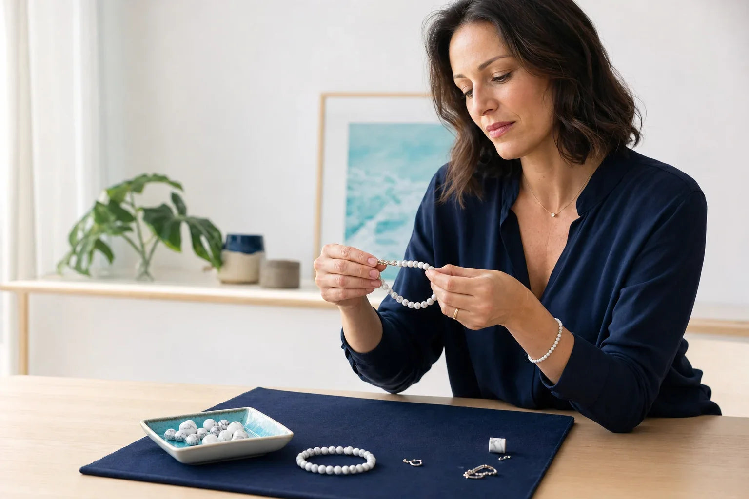 Adulte contrôlant l’élastique et les apprêts d’un bracelet en howlite avant de le porter