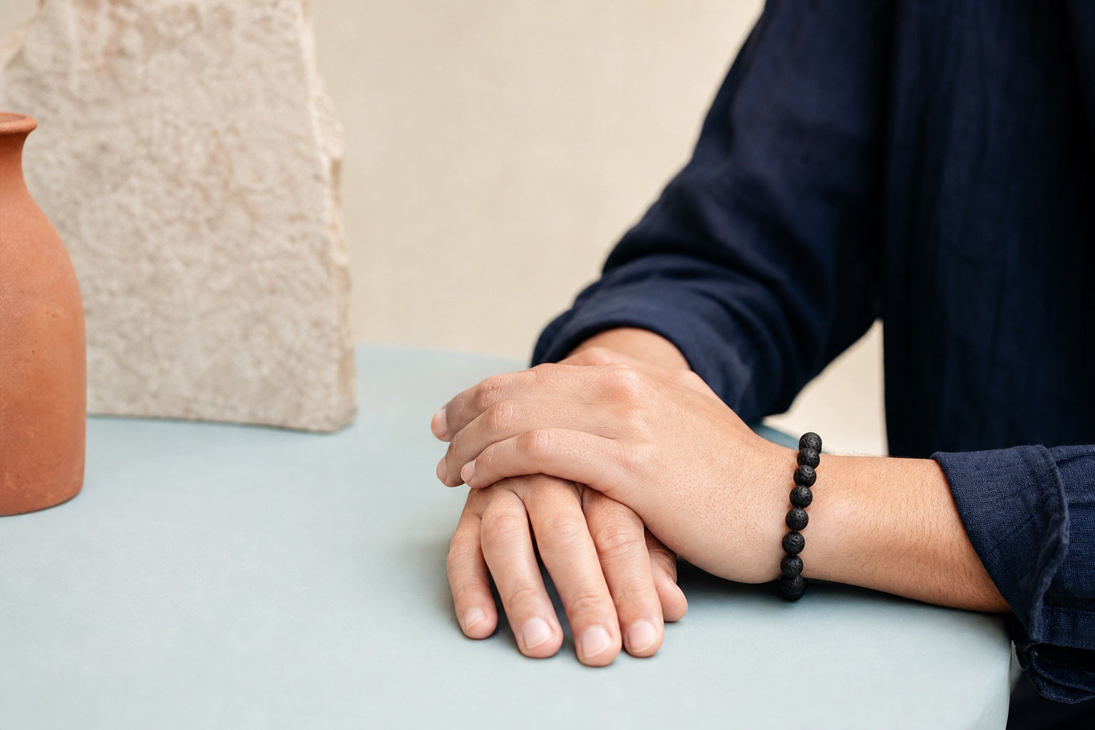 Bracelet en pierre de lave porté au poignet gauche