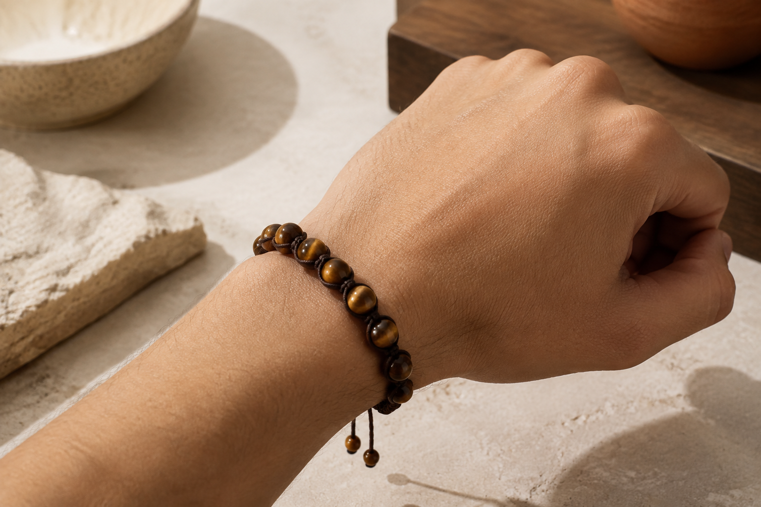 Bracelet Shamballa en œil de tigre porté au poignet avec cordon brun ajustable