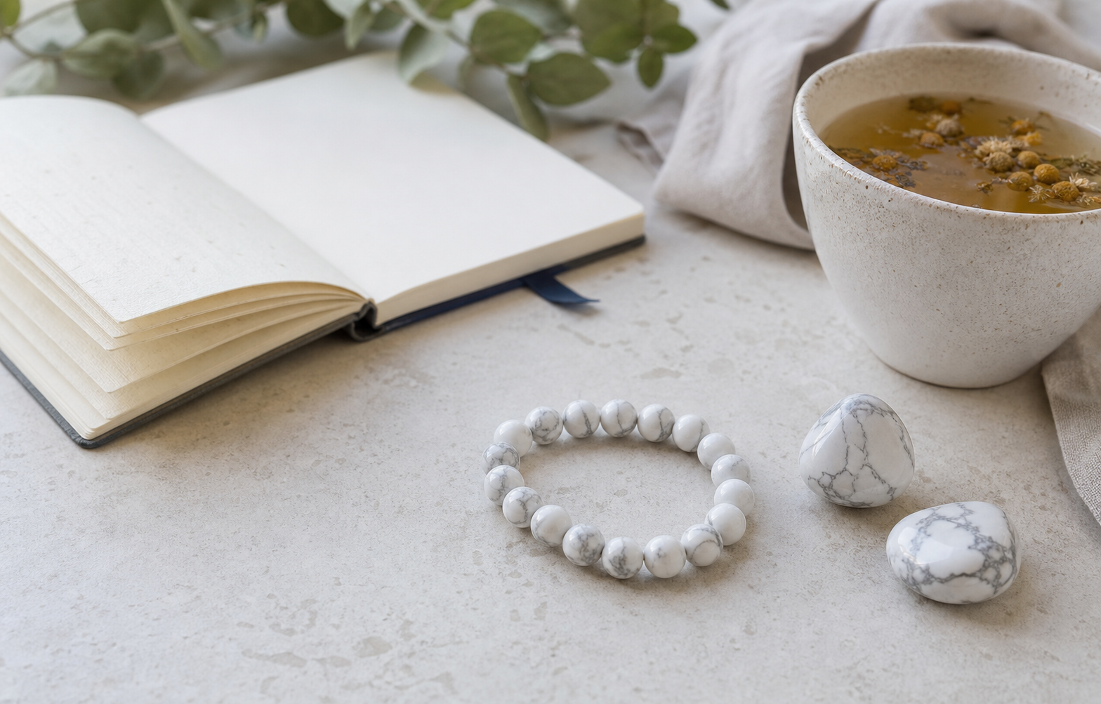 Bracelet et pierres de howlite dans une ambiance calme avec carnet et infusion