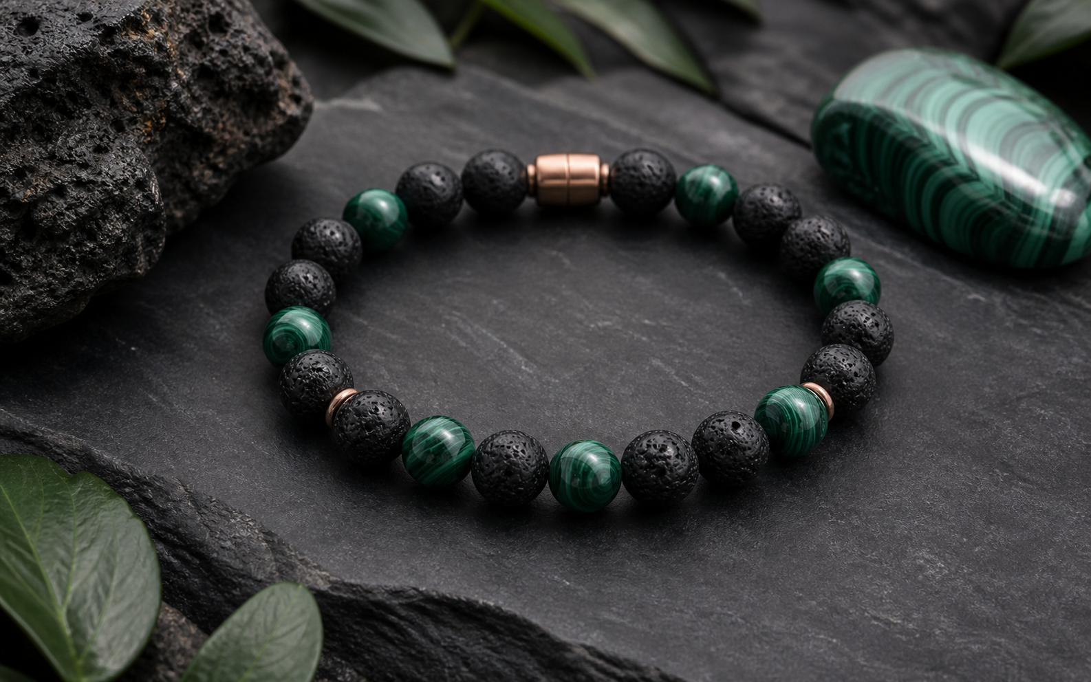 Bracelet en pierre de lave noire et malachite verte sur une dalle anthracite