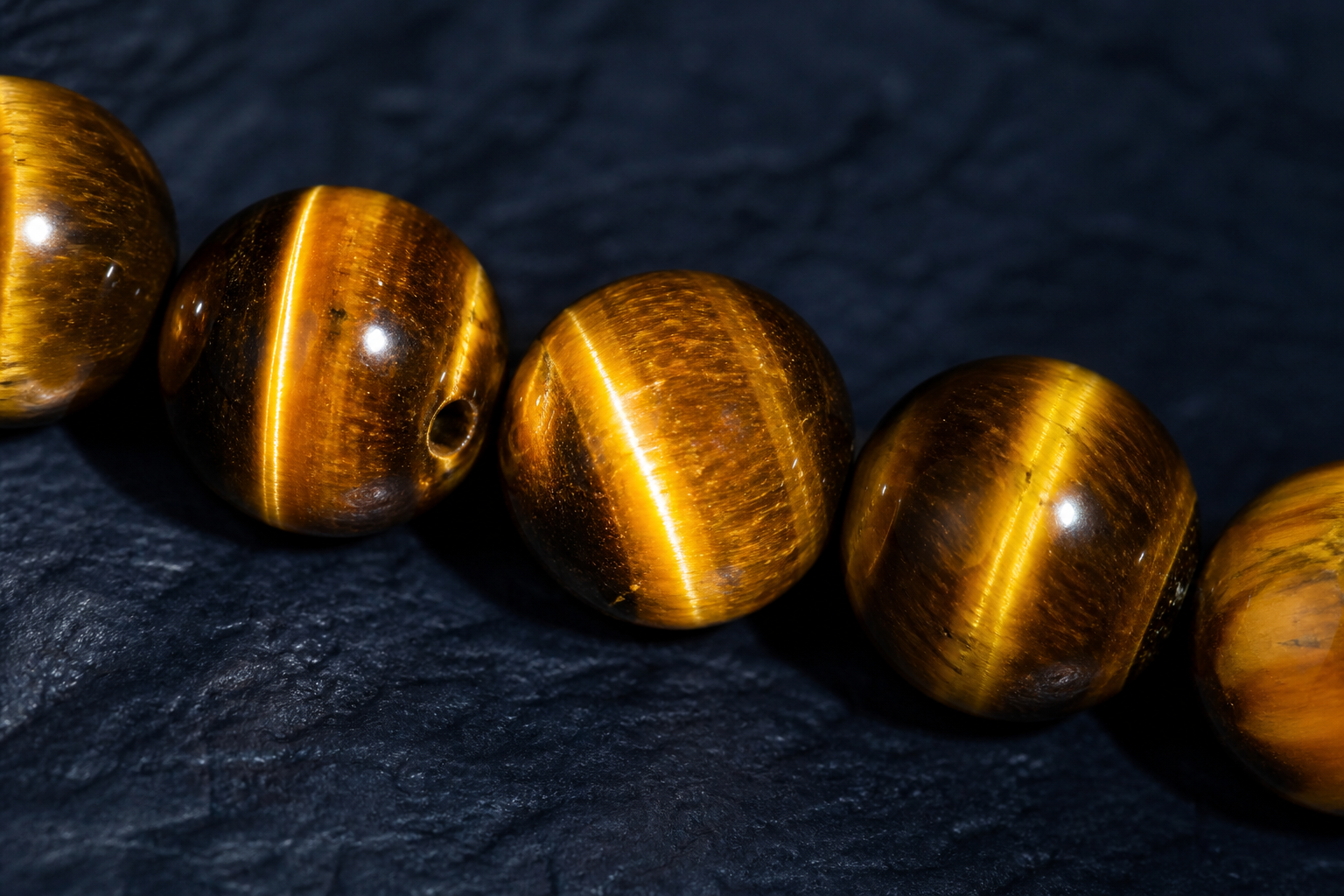 Perles d’œil de tigre montrant une bande lumineuse chatoyante