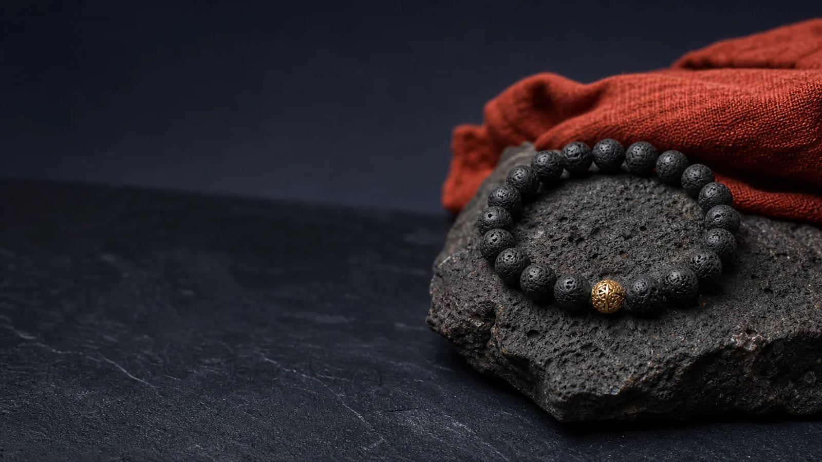 Bracelet en pierre de lave sur roche volcanique, évocation symbolique de l’ancrage