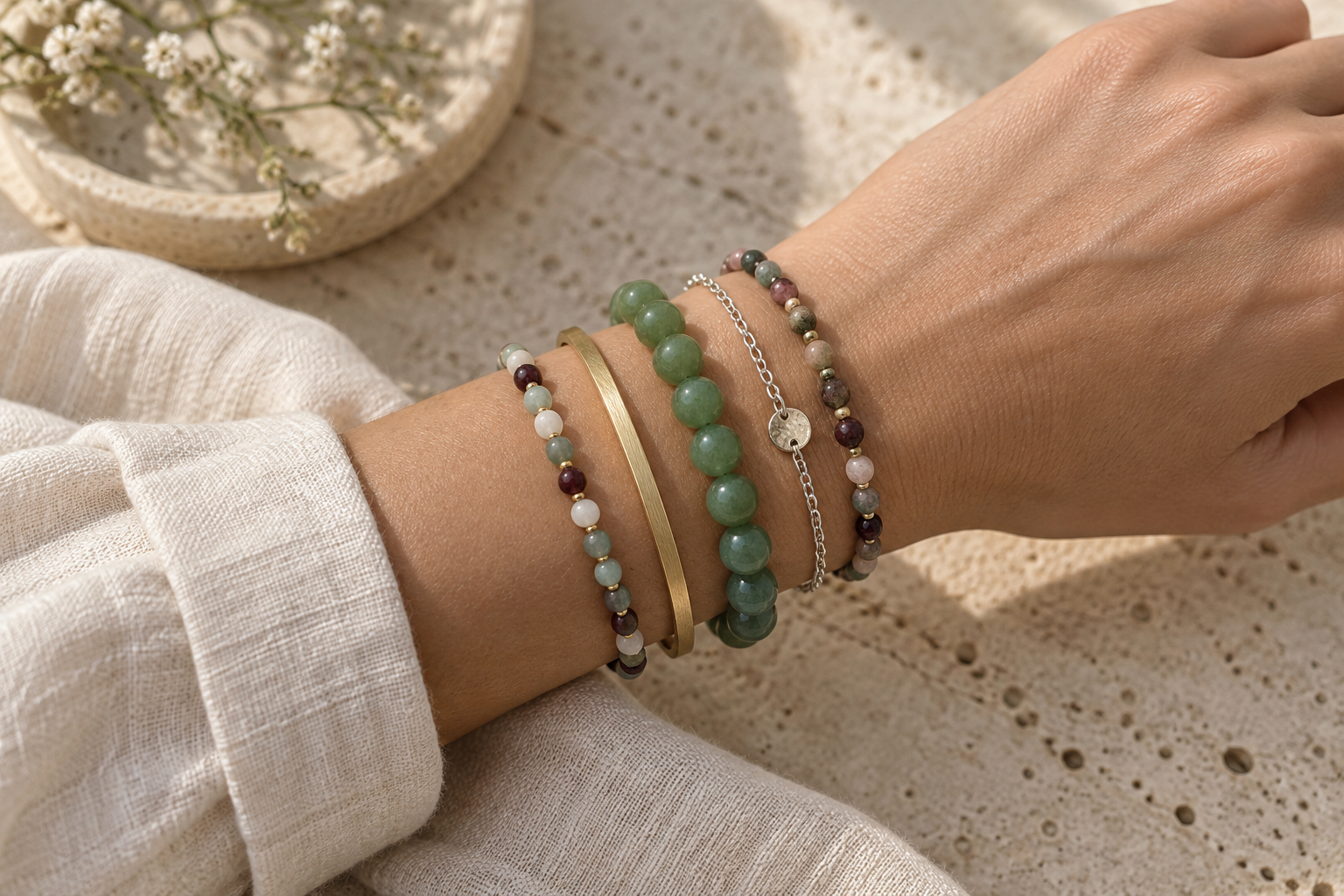 Accumulation harmonieuse de bracelets en aventurine, pierres fines et métaux mélangés